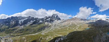 Matterhorn ve Plato Rosa 'nın Breuil-Cervinia üzerindeki geniş manzarası, dağlık çayırlar, kayak yolları ve yaz bulutlarının altındaki buzulları gösteriyor..