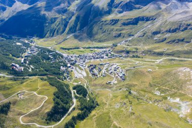İtalyan Alpleri 'ndeki Breuil-Cervinia tatil köyünün yüksek hava manzarası, yaz aylarında kümelenmiş otelleri, kayak altyapısını ve dolambaçlı vadi yollarını gösteriyor..