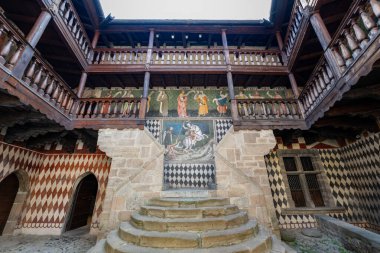 Fenis, İtalya - 2 Ağustos 2025: Aosta Vadisi 'ndeki Fnis Kalesi' nin ortaçağ iç avlusu, taş merdiven, Gotik freskler ve ahşap galeriler gösteriliyor..