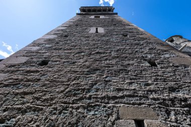 Aosta Vadisi 'ndeki ortaçağ Fenis Kalesi' nde açık yaz gökyüzü altındaki sert taş savunma kulesinin alçak açılı görüntüsü..