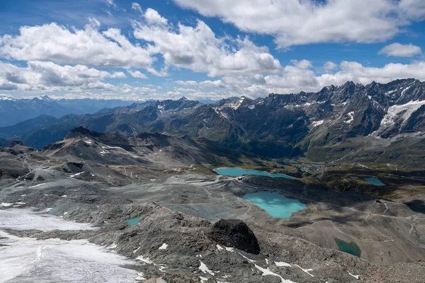 Testa Grigia 'dan yüksek irtifa manzarası kayalık buzul düzlükleri ve Valtournenche' nin yukarısındaki turkuaz alp gölleri Pennine Alpleri.