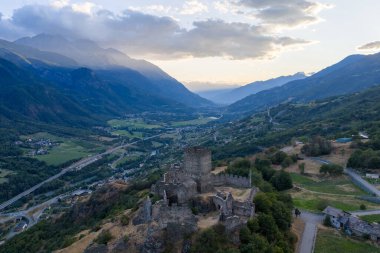 Aosta Vadisi 'ne bakan ortaçağ Castello di Cly harabelerinin ve Saint-Denis yakınlarındaki Alp dağlarının hava manzarası..