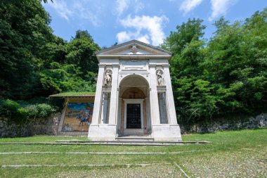 Sacro Monte di Varese 'deki Neoklasik Şapel III, mermer kapılı, yontulmuş azizler ve ormanın ortasında fresk duvarlı.