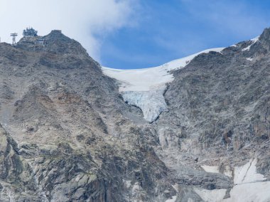 Dik bir kaya yüzeyi ve Pavillon du Mont Frety yakınlarındaki Mont Blanc kütlesinde Courmayeur 'un üstündeki buzulun yakın hava görüntüsü..