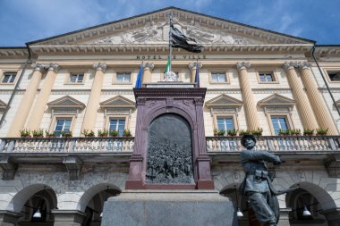 Birinci Dünya Savaşı Anıtı Aostas neoklasik Hotel de Ville 'in önünde açık yaz gökyüzü altında Düşmüş ve Alp asker heykeli.