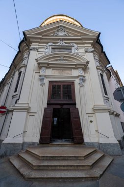 Torino 'daki Chiesa della Visitazione Barok cephesinin düşük açılı görüntüsü, süslü sıva dekorasyonunu ve ahşap kapıyı gösteriyor.