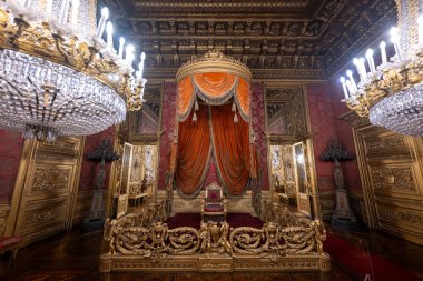 Torino, İtalya - 10 Ağustos 2025: Torino Kraliyet Sarayı 'ndaki Barok taht odası, yaldızlı ahşap işçiliği, kristal avizeler ve Savoy Sarayı' nın zengin kırmızı örtüsü.