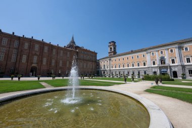 Torino Kraliyet Bahçeleri 'ndeki merkez çeşme, Palazzo Reale tarafından çerçevelenmiş ve Savoy sarayının kanatları açık bir gökyüzünün altında..
