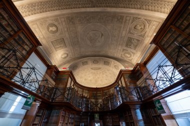 Torino, İtalya - 11 Ağustos 2025: Turin Kraliyet Kütüphanesi 'nin fıçı kemerli okuma odası, süslü sıva tavanı, ahşap kitaplıklar ve demir galeri balyaları.