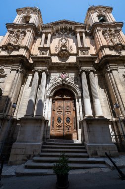 Valletta 'daki Batık Kilisesi' nden Aziz Paul 'un barok kireçtaşı cephesinde oyulmuş sütunlar, oyuklar ve yaz güneşi altında süslü ahşap kapılar yer alıyor..