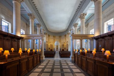 Valletta, Malta - 12 Ağustos 2025: Valletta 'da St Pauls Pro-Katedrali' nin Neoklasik najı, tavanı, Corinthian sütunları, ahşap koro tezgahları ve sıcak lamba aydınlatmasını gösteriyor.