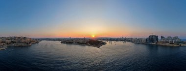 Günbatımında Marsamxett Limanı 'nın hava manzarası modern Sliema rıhtım kulelerine bakan Fort Manoel ve Vallettas kireçtaşı kalelerini gösteriyor..