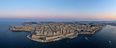 Alacakaranlıkta Valletta yarımadasının yüksek hava manzarası, güçlendirilmiş kireçtaşı kaleleri, Akdeniz 'deki Barok kubbeleri ve Grand Harbor' u gösteriyor..