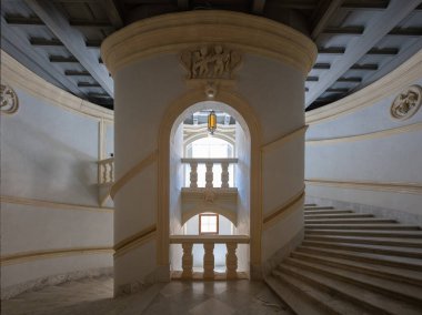 Valletta, Malta - 13 Ağustos 2025: Valletta 'daki Grandmaster Sarayı' nın iç merdiven boşluğu, kıvrımlı beyaz duvarlar, taş basamaklar, balatalar ve gün ışığıyla aydınlanan kemerli açıkları gösteriyor..