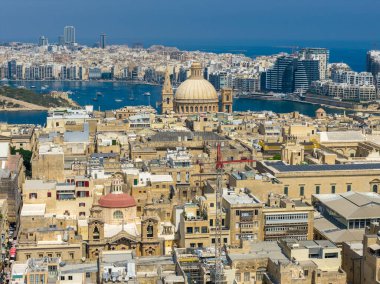 Valletta, Malta 'nın havadan görünüşü yoğun kireçtaşı çatıları ve parlak yaz ışığında Karmelit Kilisesi' nin belirgin kubbesini gösteriyor..