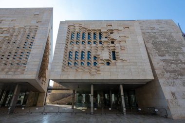 Valletta 'daki Maltas Parlamentosu' nun alçak açılı manzarası. Pilotun üzerindeki modern kireçtaşı hükümet binası. Pencere perdeleri ve cam girişi var..