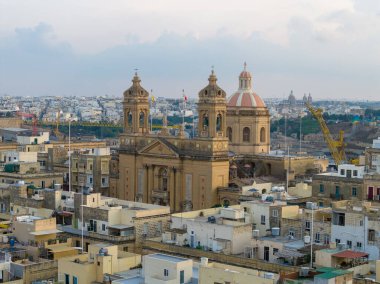 Isla (Senglea) Bazilikası ile Bakire Meryem 'in doğuşu kubbeleri ve kireçtaşı çatıların üzerinde yükselen çan kuleleri, Malta.