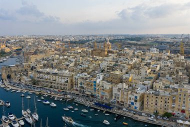 Birgu 'nun (Vittoriosa) liman manzarası, kireçtaşı binalar, yat limanları ve Malta' daki Grand Harbour boyunca uzanan tekneler..