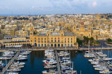 Birgu rıhtımındaki Malta Denizcilik Müzesi 'nin manzarası. Kireçtaşı binalar, marina yatları ve Senglea silueti Grand Harbour boyunca uzanıyor..