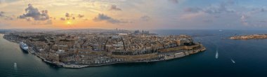 Günbatımında Grand Harbour suyu, yolcu gemisi ve açık denizle güçlendirilmiş bir yarımadada Valletta 'nın geniş hava manzarası..