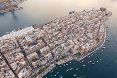 Fort Angelo yarımadası ile Birgu (Vittoriosa) liman manzarası, Grand Harbour, Malta 'da kireçtaşı binalar, botlar ve yatlar.