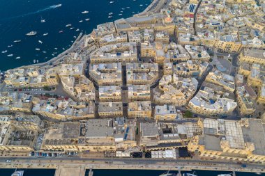 Malta 'daki Birgu (Vittoriosa) limanı, yoğun kireçtaşı binalar, marina yatları ve Grand Harbour boyunca tarihi güçlendirilmiş limanı gösteriyor..