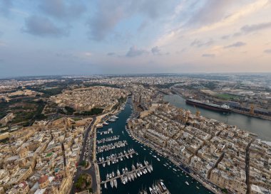 Günbatımında Vittoriosa (Birgu) limanı, yat dolu liman, kireçtaşı şehir blokları ve Grand Harbour rıhtımı, Malta.