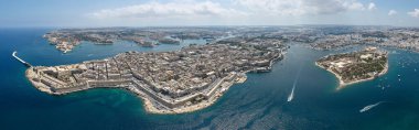 Marsamxett Limanı ile Grand Harbour arasında güçlendirilmiş Vallettas panoramik havası, kireçtaşı şehir blokları, deniz duvarları, botlar ve mavi Akdeniz sularıyla.