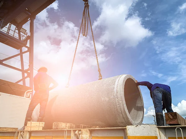 İşçiler karavanın zeminindeki beton boruyu sarı ışıkla dolduruyorlardı.