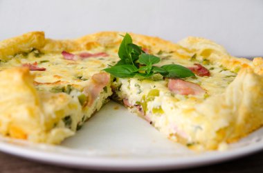 Ev yapımı ıspanak ve Pastırmalı yumurta Quiche pasta kabuk içinde parça plaka üzerinde kesme. Fransız mutfağı