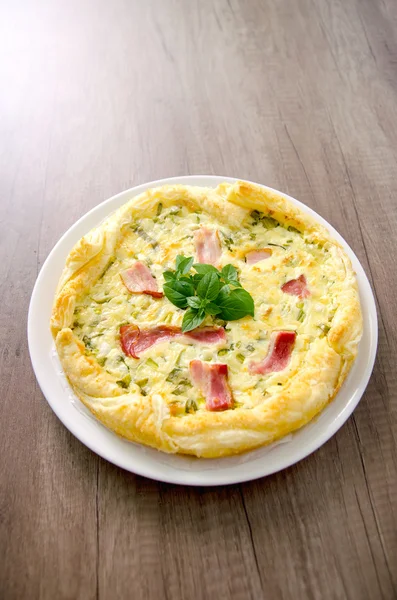 Hausgemachte Spinat-Speck-Ei-Quiche in einer Tortenkruste auf Holzplatte. Französische Küche — Stockfoto