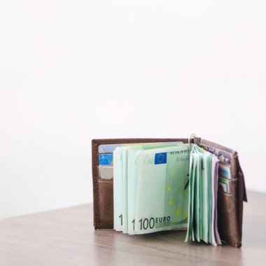 Ahşap masa üzerinde euro para birimi ile açık cüzdan