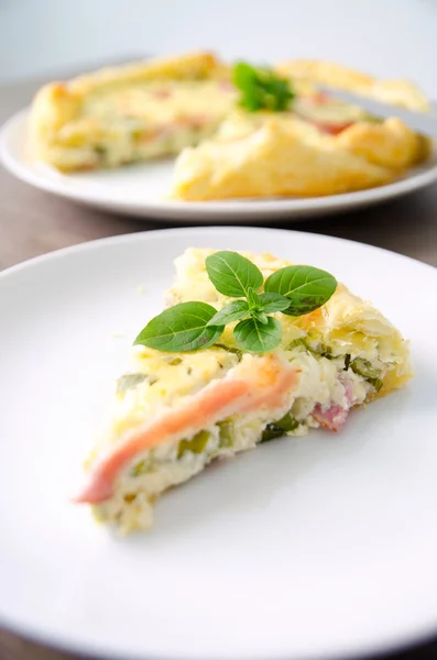 Hausgemachte Spinat-Speck-Ei-Quiche in einer Tortenkruste geschnitten Stück auf Teller. Französische Küche — Stockfoto