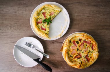 Ev yapımı ıspanak ve Pastırmalı yumurta Quiche ahşap tahta üzerinde bir pasta kabuk içinde. Fransız mutfağı düz tasarım