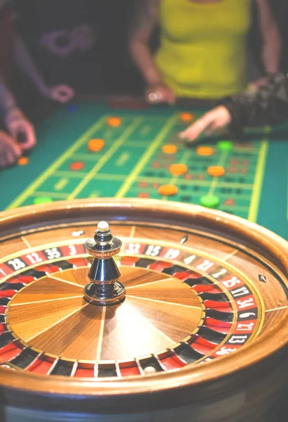 Roulette in motion. Green table with colored chips ready to play