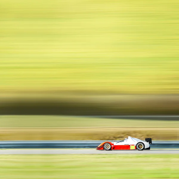 Formula one race car on speed track - motion blur background wit — Stock Photo, Image