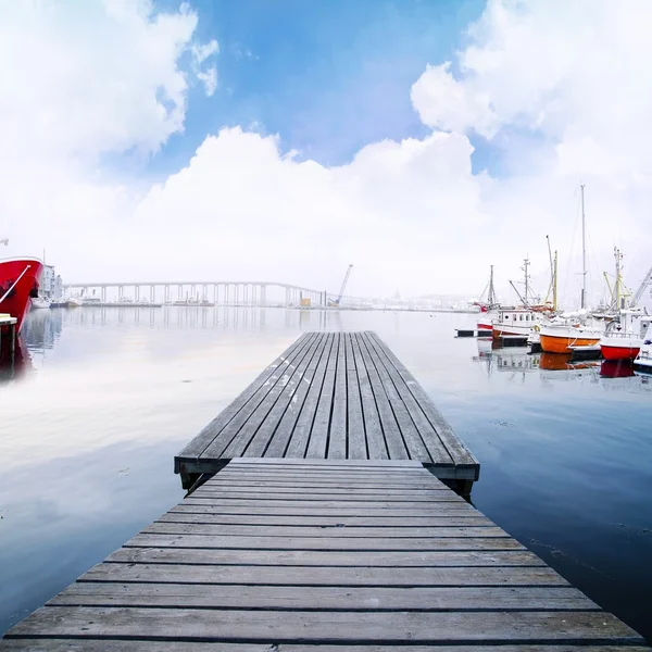 Pasarela de madera en el puerto con barcos y hermoso paisaje nublado — Foto de Stock