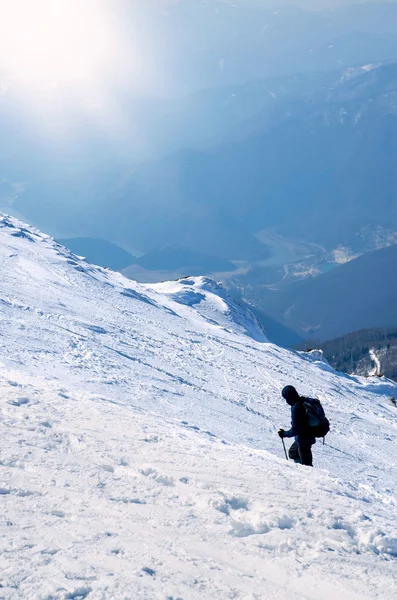 맑은 겨울 날에 눈 덮인 산의 정상에가 하는 산악인 — 스톡 사진