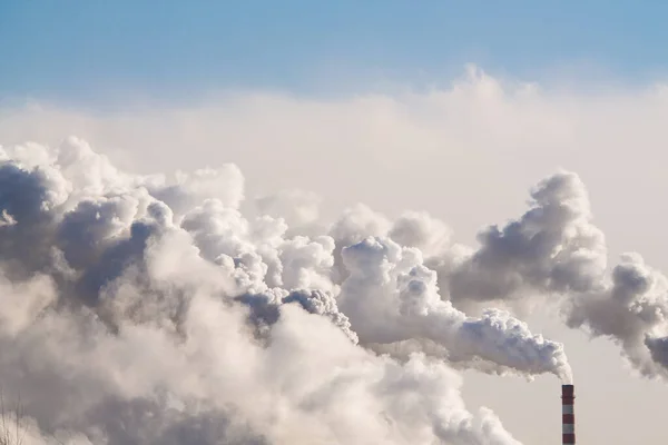 Industriële schoorstenen met zware rook die luchtverontreiniging veroorzaken op de blauwe lucht achtergrond — Stockfoto