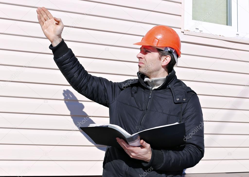 Worker on a construction site in winter looks at the drawing