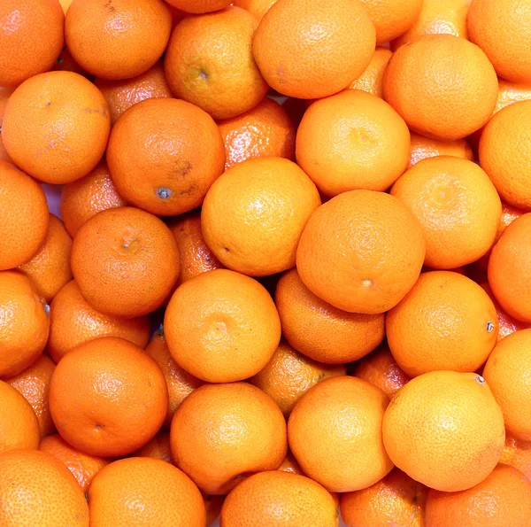 Hintergrund aus vielen leuchtend orangen Mandarinen — Stockfoto