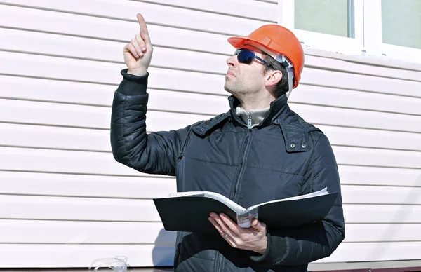 Travailleur sur un chantier de construction en hiver regarde le dessin — Photo