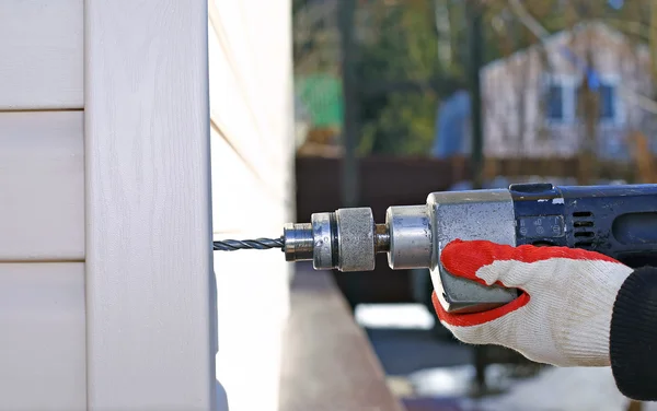 Worker at construction site drills wall drilling machine — Stock Photo, Image