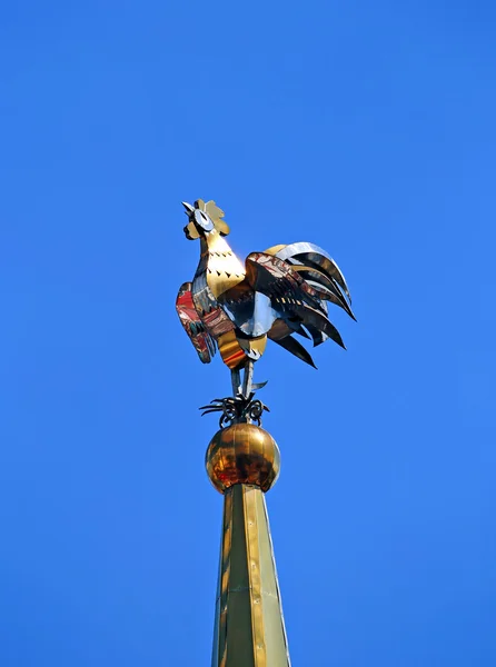 Weathervane in de vorm van een gouden haan op de toren — Stockfoto