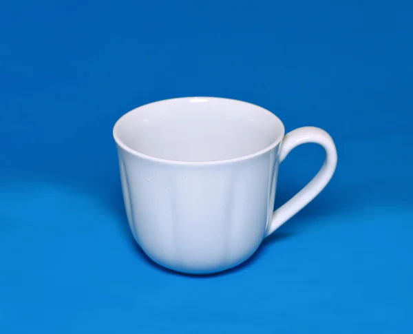 White cup on a blue background — Stock Photo, Image