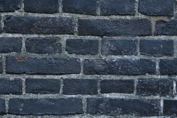 Textura de una pared de ladrillo quemado negro cubierto de hollín — Foto de Stock