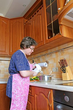 kadın ev hanımı bir mikser kullanarak yemek hazırlar