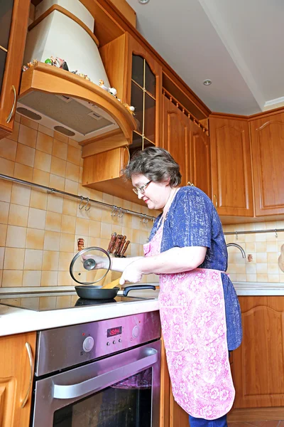 Mujer ama de casa freír comida en una sartén — Foto de Stock