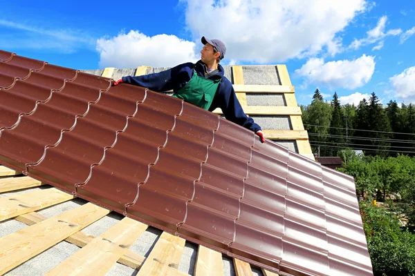 Işçinin metal kiremit çatı koyar. — Stok fotoğraf