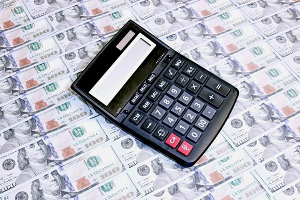 Calculator on background of hundred dollar bills — Stock Photo, Image